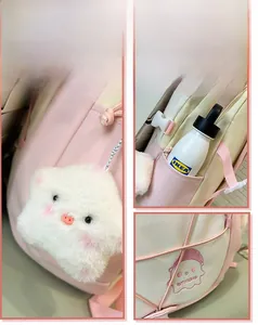 Detail view of pink backpack featuring cute cartoon plush pendant and side water bottle pocket