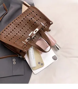 Interior detail of brown laser-cut tote bag showing large capacity for tablet and phone