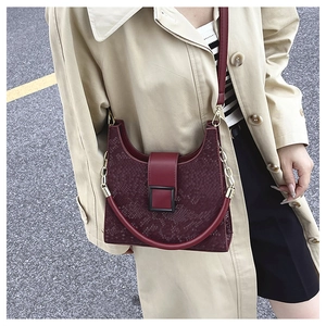 Détail du sac bandoulière bordeaux avec gaufrage serpent, boucle métal et poignée ronde