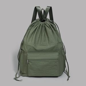 Detail of dark green lightweight waterproof nylon backpack with drawstring closure and front pocket
