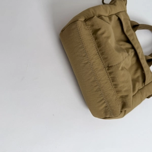 Detail of durable nylon fabric texture and reinforced double stitching on casual handbag