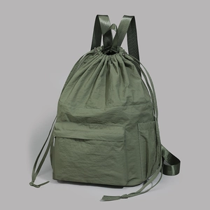 Detail view of army green nylon drawstring backpack with multi-pocket design and texture