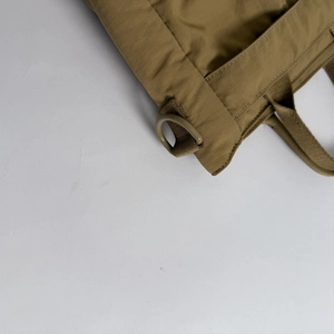 Detail of tear-resistant nylon texture and D-ring on the tan brown crossbody bag