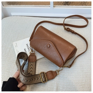 Dettaglio borsa a tracolla vintage marrone con cinturini in pelle e tessuto jacquard