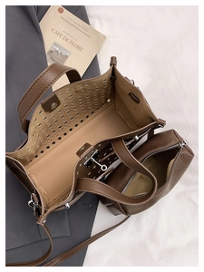 Detail view of brown lychee grain leather tote with laser-cut hollow design and inner pouch