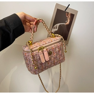 Detailed macro view of pink tweed box bag featuring dual zippers and vintage gold floral buckle