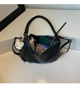 Detailed top view of a black hobo bag interior holding a phone, water bottle, and pouches