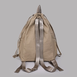 Rear view of khaki drawstring backpack featuring wide straps and textured nylon fabric
