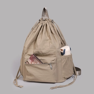 Macro detail of khaki water-resistant nylon backpack with drawstring and front zipper pocket