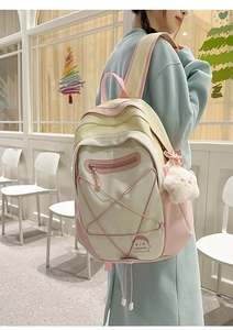 Close-up of pastel backpack with cute ghost embroidery and plush cloud charm