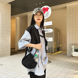 Close-up of black nylon crossbody bucket bag with mesh side pocket for water bottle storage