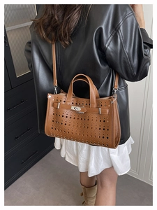 Detail of brown laser-cut tote bag with silver turn-lock and grain texture detail