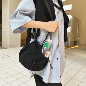 Detail of nylon bucket bag mesh pocket holding a water bottle for outdoor utility
