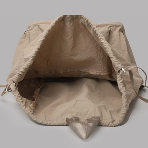 Detail view of the spacious interior of a khaki nylon backpack with drawstring closure