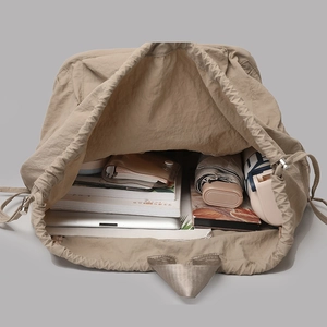 Top view of large capacity drawstring backpack interior showing books and laptop storage