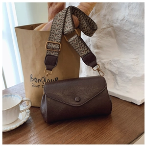 Dettaglio della borsa a tracolla marrone vintage con ampia tracolla in stile etnico