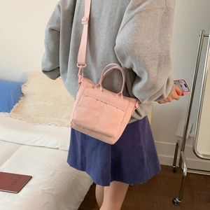 Detail of pink nylon crossbody bag with adjustable strap and quilted puff texture