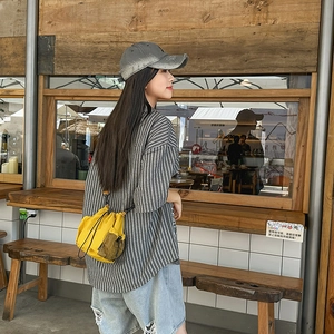 Yellow nylon mini drawstring bucket bag with mesh side pocket styled on a casual model