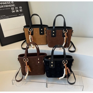 Detailed view of four colorful suede bucket bags with star patterns and beaded charms