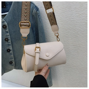 Dettaglio della borsa beige vintage con tracolla larga etnica e finiture in oro