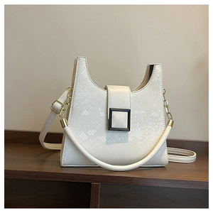 Detail of white snake-textured leather handbag with square buckle and gold chain strap