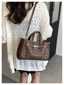 Brown hollow-out leather handbag with metal buckle and detachable strap detail