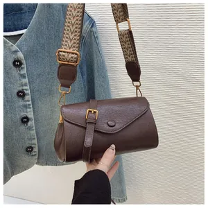 Dettaglio borsa a tracolla marrone vintage con pelle cerata e ampia tracolla etnica
