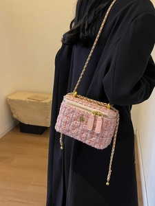 Chic pink tweed crossbody chain bag with vintage gold floral buckle on black blazer