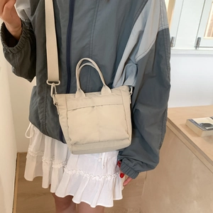 Close-up of lightweight apricot nylon crossbody bag with adjustable wide shoulder strap