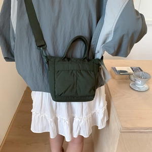 Detail of army green nylon mini tote bag with adjustable shoulder strap and handle