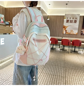 Detailed close-up of macaron color block backpack with fluffy cloud charm and elastic cords