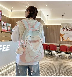 Detail showing the pastel blue and pink backpack with star plush and rope decoration