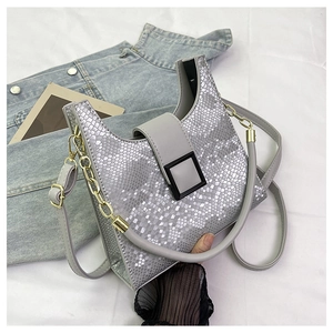 Detail of silver snake-embossed handbag with metallic texture and black square buckle