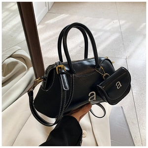 Detail of black glossy Boston bag and matching round pouch with silver letter 'a' print