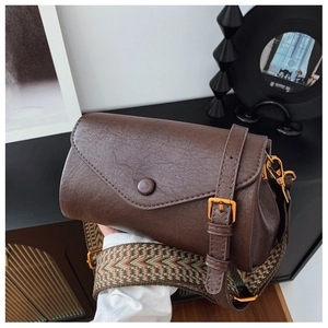 Dettaglio borsa vintage marrone caffè con trama litchi e tracolla larga intrecciata