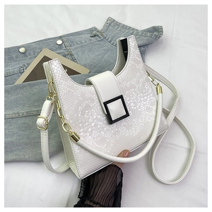 Detail of white snake-textured leather handbag featuring a matte black square buckle accent