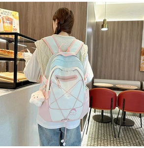 Close-up of stylish pastel patchwork backpack with elastic cords and plush star accessory