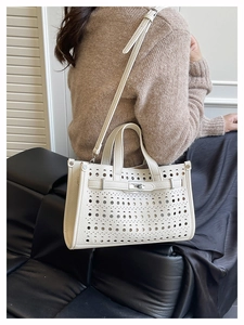 Detail of white hollowed-out tote bag with elegant laser-cut patterns and silver twist lock
