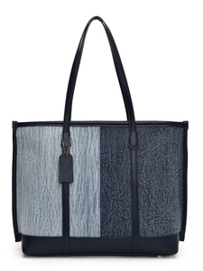 Sac cabas en denim contrasté avec finitions en cuir bleu et anses sur fond blanc