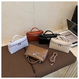 Five crocodile pattern handbags in white orange black beige and brown shown on display