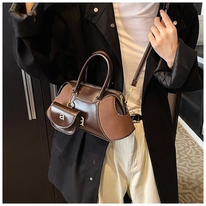 Detail of dark brown retro boston bag with mini pouch and polished metal accents