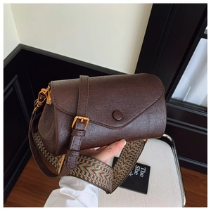 Dettaglio borsa vintage marrone con tracolla geometrica larga e chiusura in ottone opaco