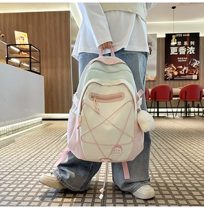 Detail showing pink and white school backpack with star cords in a cafe setting