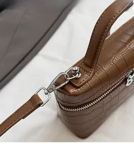 Detailed view of brown crocodile texture leather and premium silver metal zipper hardware