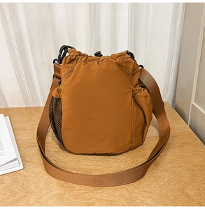 Caramel nylon bucket bag detail showing drawstring closure and side mesh pocket