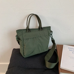 Detail of army green nylon tote bag with reinforced handles and removable shoulder strap