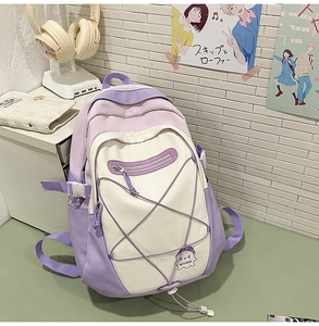 Detailed view of school backpack featuring star cross lacing and embroidery in lavender