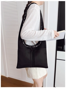 Détail du sac cabas noir rétro avec des rivets argentés et deux poches avant