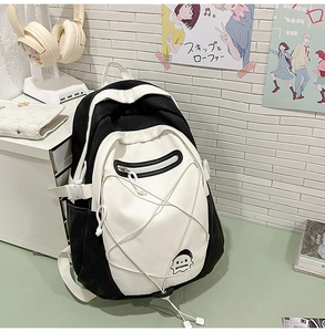 Detail of white canvas backpack with cartoon ghost logo and stylish bungee cords