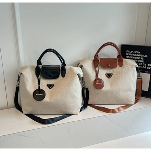 Detail of canvas travel tote bags with leather trim, metal accents and woven straps